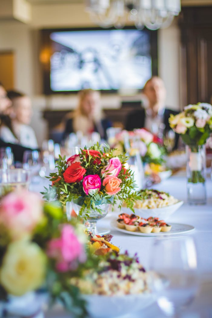 gallery-2 Beautiful dining setup with vibrant floral arrangements and gourmet dishes, perfect for celebrations.