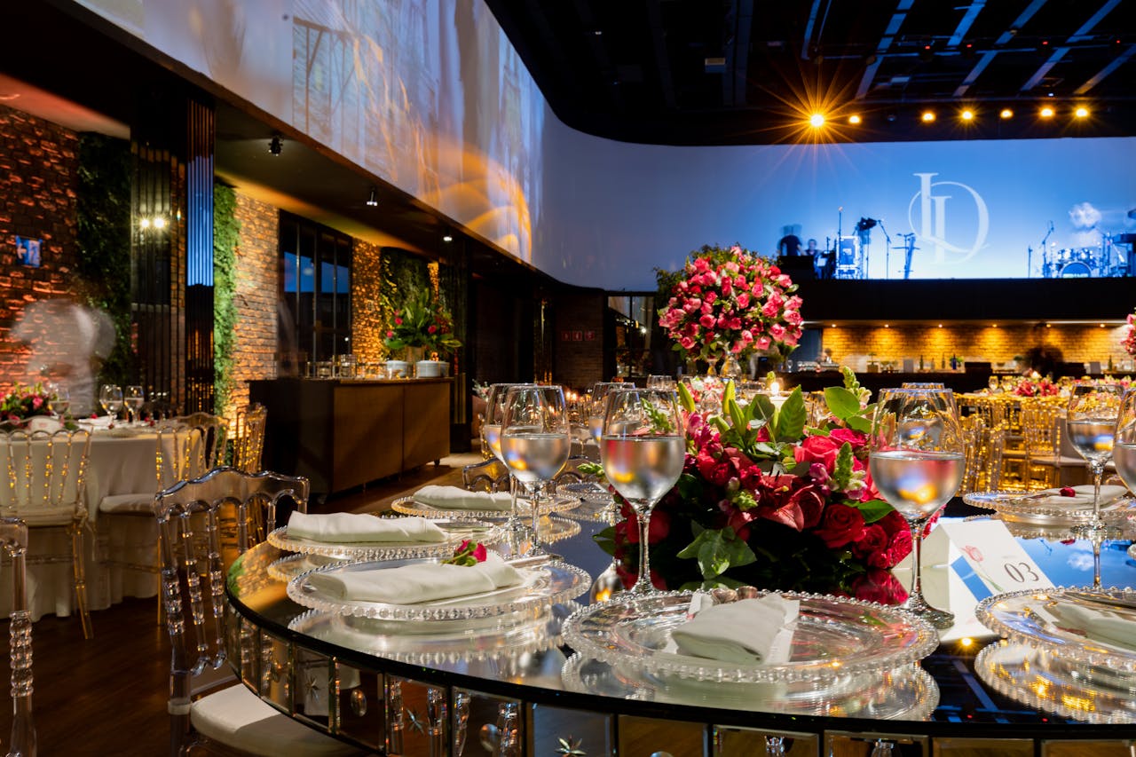 services-03 Luxurious wedding venue with detailed table settings, glassware, and vibrant floral arrangements.