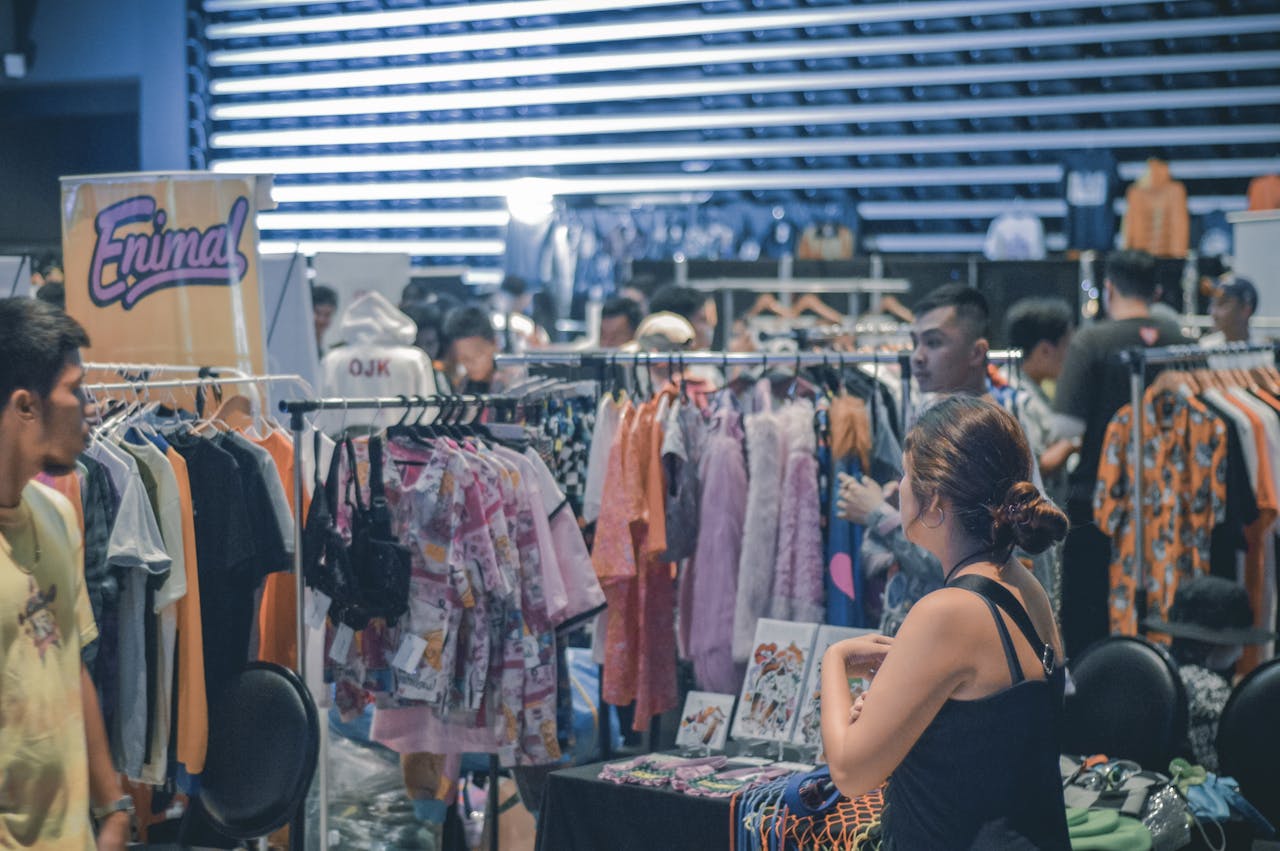 our-experience Vibrant indoor clothing market scene with diverse shoppers browsing and buying fashionable apparel.