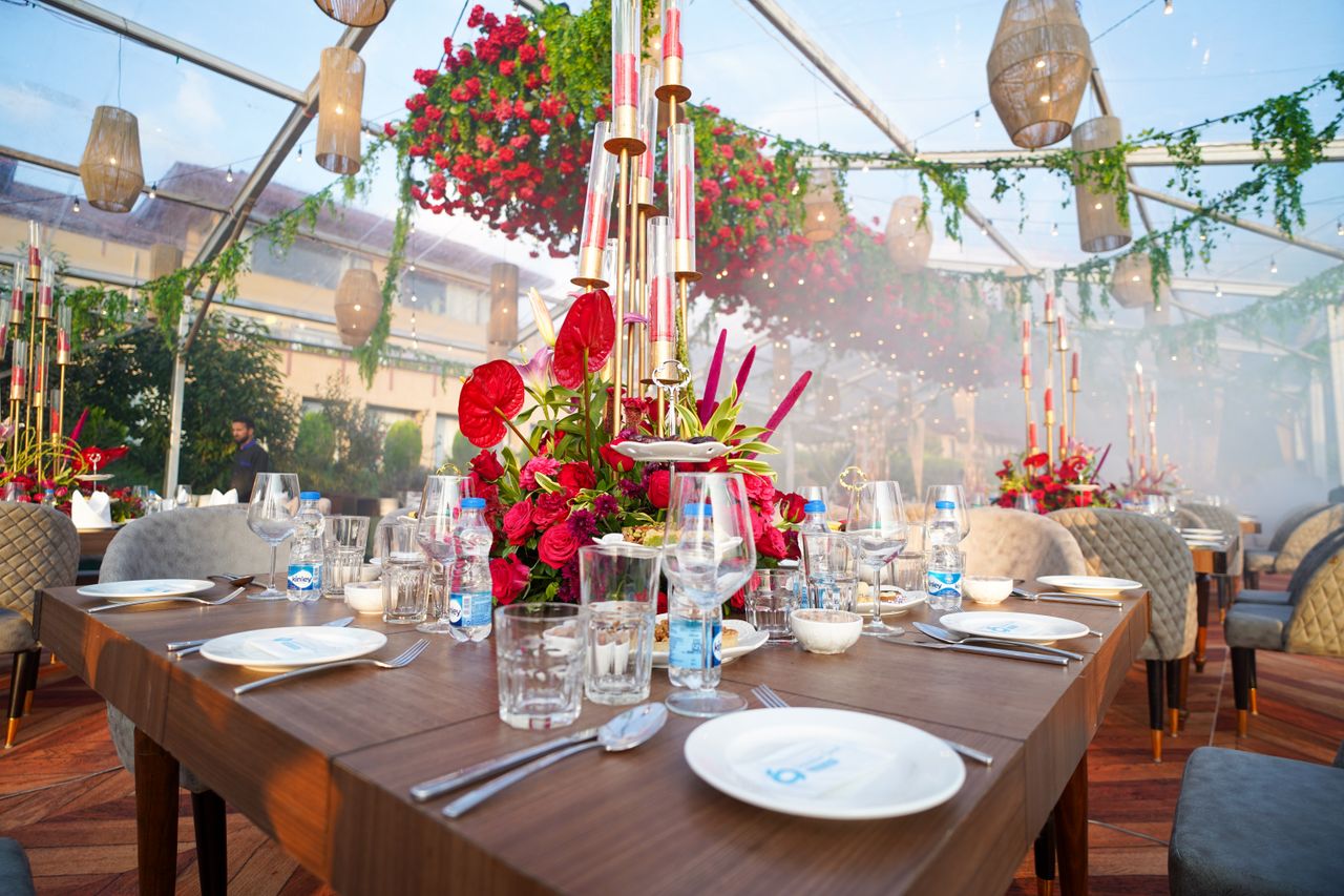 gallery-1 Exquisite dining setup in a glass pavilion with vibrant floral arrangements and elegant tableware in Srinagar.