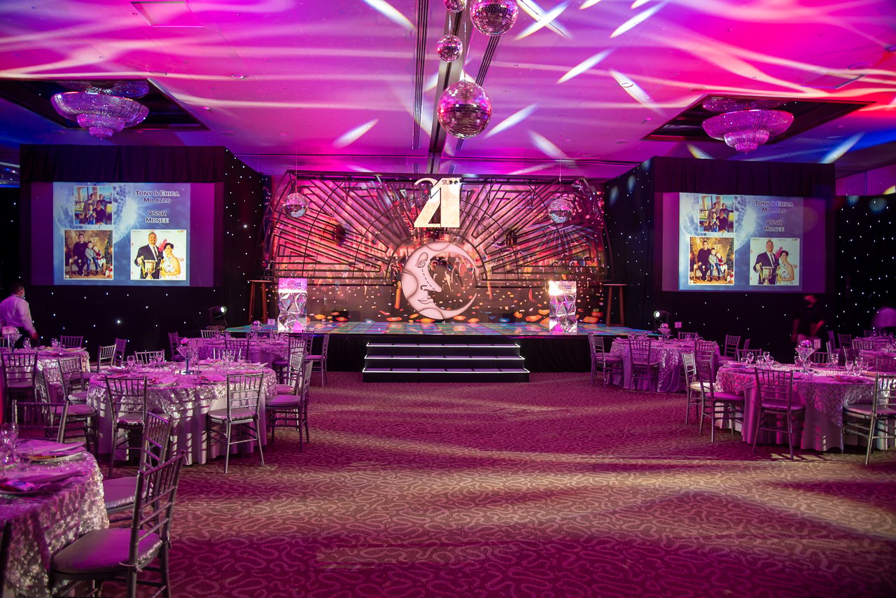 hero-img-02 Vibrant event hall set up for a themed dinner with elegant decorations and lighting.