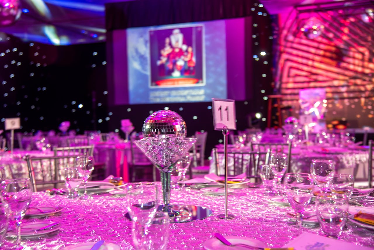 about-01 Lavish themed dinner setup with disco balls and purple lighting for a glamorous event.